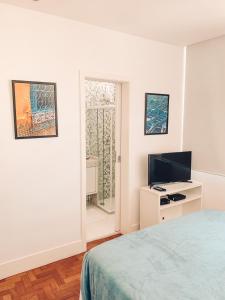 um quarto com uma cama, uma televisão e uma janela em Stylish Copacabana Apartment no Rio de Janeiro