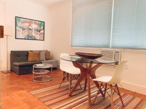 uma sala de estar com uma mesa e cadeiras e um sofá em Stylish Copacabana Apartment no Rio de Janeiro