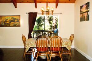 a dining room table with four chairs and a window at Cedar Ridge Retreat Lake Almanor in Lake Almanor