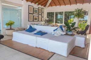 a living room with white couches and blue pillows at Pousada Ao Por do Sol in Búzios +167 photos