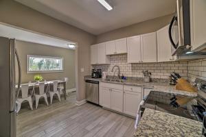 a kitchen with white cabinets and a dining table at Home with Hot Tub Less Than 2 Mi to Downtown Richmond! in Richmond