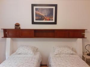 um quarto com duas camas e uma prateleira na parede em Inka Ayllu Hospedaje em Lima
