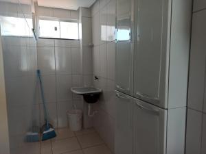 a small kitchen with a sink and a refrigerator at Lotus Apartamentos in Santarém