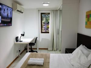 巴西利亚Life Resort às margens do lago的一间卧室，配有一张床、一张书桌和一扇窗户 更多24张照片