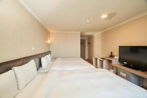 Habitación de hotel con cama y TV de pantalla plana. en HengChang Business Hotel en Keelung