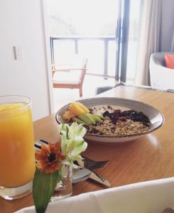 a plate of food on a table with a glass of orange juice at Kaiteriteri Reserve Apartments in Kaiteriteri