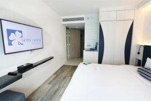 a hotel room with a bed and a flat screen tv at Hotel Clover Patong Phuket - SHA Plus in Patong Beach