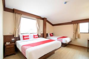 a bedroom with two beds with red and white sheets at OYO 635 Sira Boutique Hotel in Chiang Mai