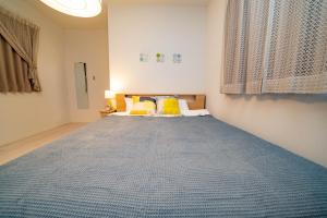 a bedroom with a large bed with yellow pillows at Tachibana in Tokyo