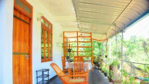 a porch with a table and chairs on a balcony at Ella Supreme Villa in Ella