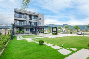 a large building with a green lawn in front of it at 礁溪320山館 Jiaoxi Shanguan B&B in Jiaoxi