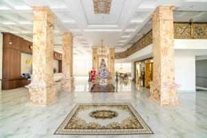 a lobby with columns and a rug at Mai Vang Hotel in Da Lat
