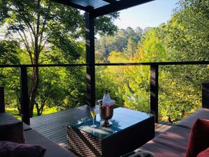 a glass table on a screened in porch with a view of trees at The Dudley Boutique Hotel in Daylesford