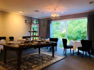 uma sala de jantar com uma mesa e uma grande janela em The Dudley Boutique Hotel em Daylesford