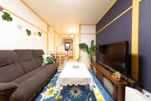 Una sala de estar con un sofá y un televisor. en Kyorakuya, en Kioto