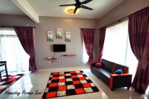a living room with a couch and a tv at Pesona Suri Homestay in Batu Pahat