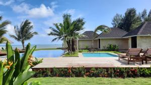 una villa con piscina e palme di The Kelong Trikora Resort a Kangkakawal
