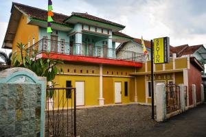 Banjar的住宿－SPOT ON 2488 Villa Tirta Melati Syariah，黄色的建筑,前面有标志