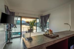 a living room with a table and a large window at The Sanctuary Nam Ngum Beach Resort in Vang Vieng