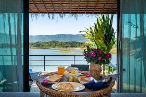 un tavolo con cibo e vista sull'acqua di The Sanctuary Nam Ngum Beach Resort a Vang Vieng