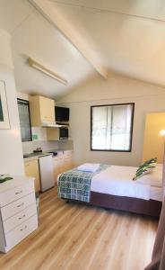 a large bedroom with a bed and a kitchen at Lilyponds Holiday Park in Mapleton