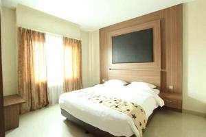Rúm í herbergi á Mutiara Suites