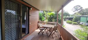 a patio with a table and chairs on a porch at Lilyponds Holiday Park in Mapleton