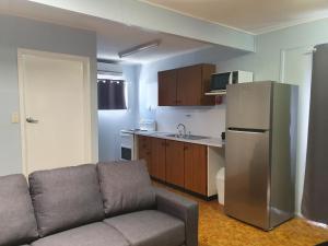 a kitchen with a couch and a stainless steel refrigerator at Horseshoe Bay Resort in Bowen