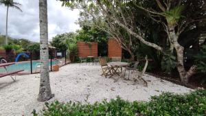 a patio with a table and chairs next to a pool at Lilyponds Holiday Park in Mapleton