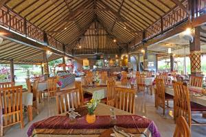 a dining room with tables and chairs in a restaurant at Bhanuswari Villas Ubud in Ubud