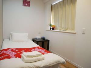 Rúm í herbergi á Tokyo shinjukutei Hotel Asahi gruop 東京新宿亭ホテル