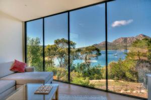 a living room with large windows and a view of a lake at Furneaux in Coles Bay