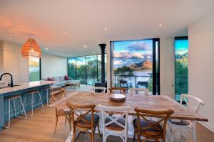 a kitchen and dining room with a large wooden table and chairs at Furneaux in Coles Bay