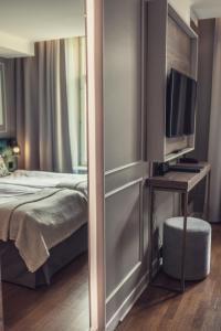 a bedroom with a bed and a desk with a television at Hotel Poseidon in Gothenburg