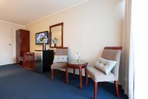 um quarto com uma mesa e cadeiras e um espelho em ibis Styles Canberra em Camberra