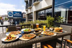 Best Western Hobart في هوبارت: طاولة مع العديد من الأطباق من المواد الغذائية والمشروبات