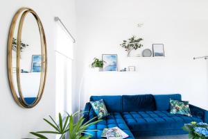 a blue couch in a living room with a mirror at P19 Boutique Villa Badacsony in Badacsonytomaj