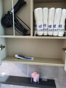 ein Regal mit Rollen Toilettenpapier und Handtüchern in der Unterkunft Jeju Hill Tower Pension in Jeju-do