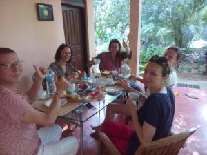 een groep mensen die rond een tafel zitten bij Pelwehera Homestay in Dambulla