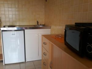 a small kitchen with a microwave and a sink at Chambres chez l'habitant Coco2 in Boulazac