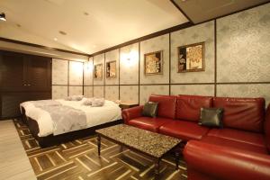 1 dormitorio con 1 cama y 1 sofá rojo en HOTEL Birth （ホテルバース）, en Himeji