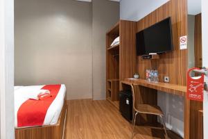 a hotel room with a bed and a tv at RedDoorz Premium near Centre Point Mall Medan in Medan