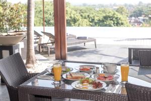 a table with plates of food and orange juice at Villa Hening Jimbaran in Jimbaran