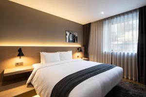 a hotel room with a bed and a lamp at Hotel28 Myeongdong in Seoul