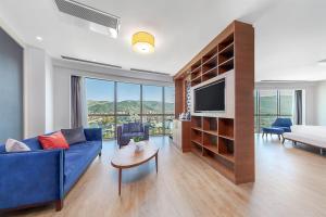 a living room with a blue couch and a tv at Dedeman Tokat in Tokat