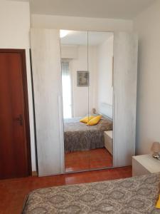 マリネッラ・ディ・サルザーナにあるVilla Manuela Apartmentのベッドルーム(鏡、ベッド付)