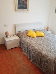マリネッラ・ディ・サルザーナにあるVilla Manuela Apartmentのベッドルーム1室(黄色い枕2つ付きのベッド1台付)