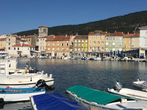 eine Gruppe von Booten, die in einem Hafen mit Gebäuden angedockt sind in der Unterkunft Apartment Filipas in Cres