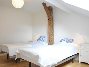 2 Betten in einem Zimmer mit weißen Wänden in der Unterkunft Beautiful Ardennes house in quiet area in Sainte-Ode
