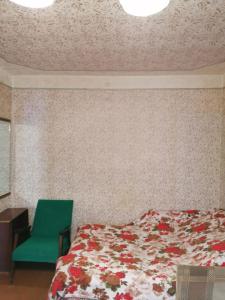 リスキにあるКвартира рядом с городским паркомのベッドルーム1室(ベッド1台、緑の椅子付)
